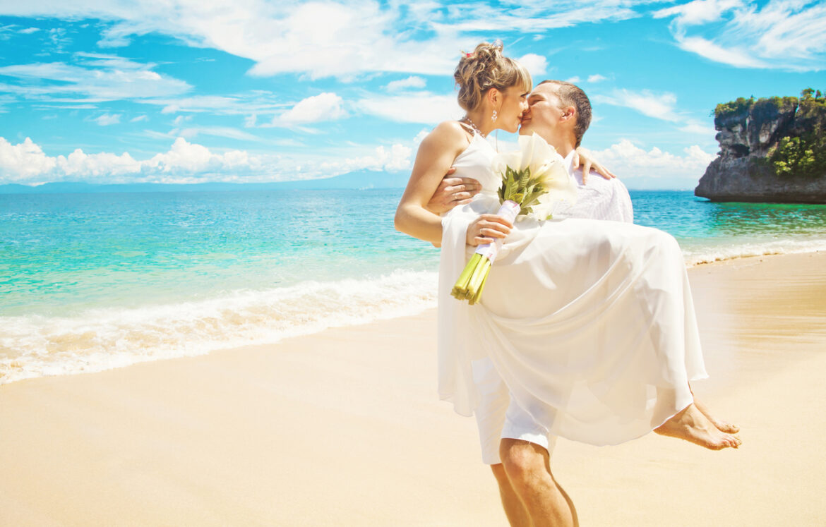 Bride and groom kissing on the beach Bali